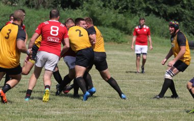 Odessa, Ukrayna - 23 Haziran 2021: Odessa Milli Takımı CREDO (kırmızı) - OLYMP-Kharkiv (sarı) in rugby 7s. Top için erkek rugby oyuncularının sert agresif dövüşü. Stadyumun yeşil çimlerinde dinamik bir oyun