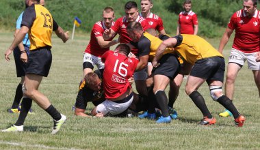 Odessa, Ukrayna - 23 Haziran 2021: Odessa Milli Takımı CREDO (kırmızı) - OLYMP-Kharkiv (sarı) in rugby 7s. Top için erkek rugby oyuncularının sert agresif dövüşü. Stadyumun yeşil çimlerinde dinamik bir oyun