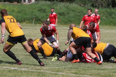 Odessa, Ukrayna - 23 Haziran 2021: Odessa Milli Takımı CREDO (kırmızı) - OLYMP-Kharkiv (sarı) in rugby 7s. Top için erkek rugby oyuncularının sert agresif dövüşü. Stadyumun yeşil çimlerinde dinamik bir oyun