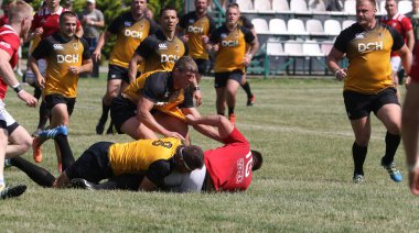 Odessa, Ukrayna - 23 Haziran 2021: Odessa Milli Takımı CREDO (kırmızı) - OLYMP-Kharkiv (sarı) in rugby 7s. Top için erkek rugby oyuncularının sert agresif dövüşü. Stadyumun yeşil çimlerinde dinamik bir oyun