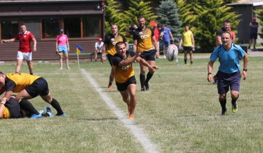 Odessa, Ukrayna - 23 Haziran 2021: Odessa Milli Takımı CREDO (kırmızı) - OLYMP-Kharkiv (sarı) in rugby 7s. Top için erkek rugby oyuncularının sert agresif dövüşü. Stadyumun yeşil çimlerinde dinamik bir oyun