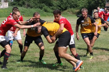 Odessa, Ukrayna - 23 Haziran 2021: Odessa Milli Takımı CREDO (kırmızı) - OLYMP-Kharkiv (sarı) in rugby 7s. Top için erkek rugby oyuncularının sert agresif dövüşü. Stadyumun yeşil çimlerinde dinamik bir oyun
