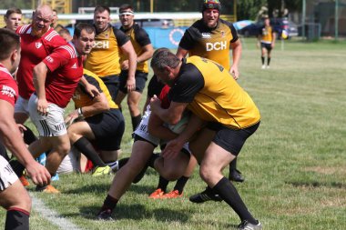 Odessa, Ukrayna - 23 Haziran 2021: Odessa Milli Takımı CREDO (kırmızı) - OLYMP-Kharkiv (sarı) in rugby 7s. Top için erkek rugby oyuncularının sert agresif dövüşü. Stadyumun yeşil çimlerinde dinamik bir oyun