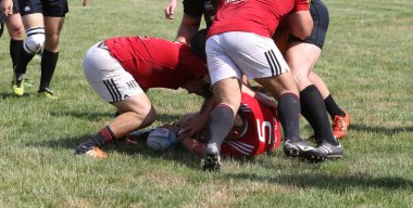 Odessa, Ukrayna - 23 Haziran 2021: Odessa Milli Takımı CREDO (kırmızı) - OLYMP-Kharkiv (sarı) in rugby 7s. Top için erkek rugby oyuncularının sert agresif dövüşü. Stadyumun yeşil çimlerinde dinamik bir oyun