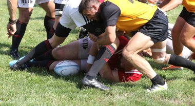 Odessa, Ukrayna - 23 Haziran 2021: Odessa Milli Takımı CREDO (kırmızı) - OLYMP-Kharkiv (sarı) in rugby 7s. Top için erkek rugby oyuncularının sert agresif dövüşü. Stadyumun yeşil çimlerinde dinamik bir oyun