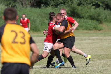 Odessa, Ukrayna - 23 Haziran 2021: Odessa Milli Takımı CREDO (kırmızı) - OLYMP-Kharkiv (sarı) in rugby 7s. Top için erkek rugby oyuncularının sert agresif dövüşü. Stadyumun yeşil çimlerinde dinamik bir oyun
