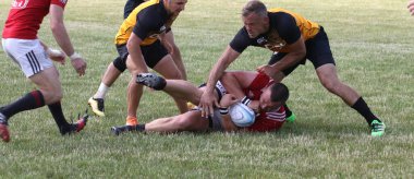 Odessa, Ukrayna - 23 Haziran 2021: Odessa Milli Takımı CREDO (kırmızı) - OLYMP-Kharkiv (sarı) in rugby 7s. Top için erkek rugby oyuncularının sert agresif dövüşü. Stadyumun yeşil çimlerinde dinamik bir oyun