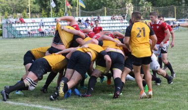 Odessa, Ukrayna - 23 Haziran 2021: Odessa Milli Takımı CREDO (kırmızı) - OLYMP-Kharkiv (sarı) in rugby 7s. Top için erkek rugby oyuncularının sert agresif dövüşü. Stadyumun yeşil çimlerinde dinamik bir oyun