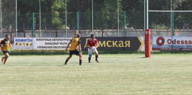 Odessa, Ukrayna - 23 Haziran 2021: Odessa Milli Takımı CREDO (kırmızı) - OLYMP-Kharkiv (sarı) in rugby 7s. Top için erkek rugby oyuncularının sert agresif dövüşü. Stadyumun yeşil çimlerinde dinamik bir oyun