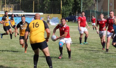 Odessa, Ukrayna - 23 Haziran 2021: Odessa Milli Takımı CREDO (kırmızı) - OLYMP-Kharkiv (sarı) in rugby 7s. Top için erkek rugby oyuncularının sert agresif dövüşü. Stadyumun yeşil çimlerinde dinamik bir oyun