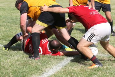 Odessa, Ukrayna - 23 Haziran 2021: Odessa Milli Takımı CREDO (kırmızı) - OLYMP-Kharkiv (sarı) in rugby 7s. Top için erkek rugby oyuncularının sert agresif dövüşü. Stadyumun yeşil çimlerinde dinamik bir oyun