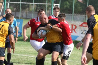 Odessa, Ukrayna - 23 Haziran 2021: Odessa Milli Takımı CREDO (kırmızı) - OLYMP-Kharkiv (sarı) in rugby 7s. Top için erkek rugby oyuncularının sert agresif dövüşü. Stadyumun yeşil çimlerinde dinamik bir oyun
