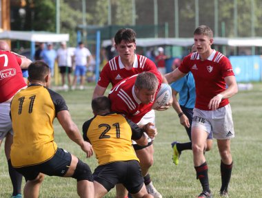 Odessa, Ukrayna - 23 Haziran 2021: Odessa Milli Takımı CREDO (kırmızı) - OLYMP-Kharkiv (sarı) in rugby 7s. Top için erkek rugby oyuncularının sert agresif dövüşü. Stadyumun yeşil çimlerinde dinamik bir oyun