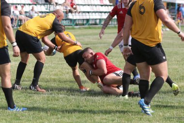 Odessa, Ukrayna - 23 Haziran 2021: Odessa Milli Takımı CREDO (kırmızı) - OLYMP-Kharkiv (sarı) in rugby 7s. Top için erkek rugby oyuncularının sert agresif dövüşü. Stadyumun yeşil çimlerinde dinamik bir oyun