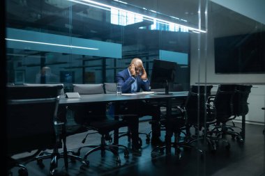 Afrika kökenli Amerikalı iş adamı karanlık bir toplantı odasında tek başına oturmuş, stres içinde başını tutuyordu. Kurumsal alanda baskıyla, teslim tarihleriyle veya iş sorunlarıyla karşı karşıya olan olgun yönetici