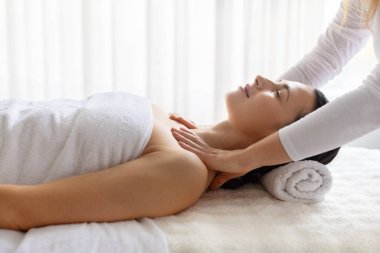 Genç güzel bir kadın üst vücut spa tedavisi görüyor, omuzları üzerinde terapi görüyor, rahatlamaya odaklanıyor, sağlık terapisi, güzellik bakımı, ve bütünsel özbakım yaşam tarzı.