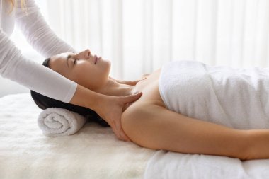 Genç ve güzel bir kadın profesyonel masaj sırasında dinleniyor, tedavi yatağında uzanıyor, sakinlik atmosferi güzellik bakımına, özgüvene ve rahatlamaya odaklanıyor.