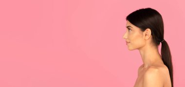 Pembe arka planda at kuyruklu ve pürüzsüz derili genç bir kadının yan profili. Boyun ve yüz hatlarını gösteren minimal cilt portresi, kopya alanı olan pankart