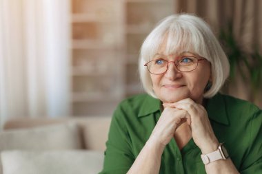 Kafkasyalı yaşlı bir kadının portresi, elleri üzerinde dinlenen ve başka tarafa bakan, düşünceli bir ifadeye, sakin bir yansımaya ve huzurlu bir emeklilik yaşam tarzına sahip yaşlı bir kadın.