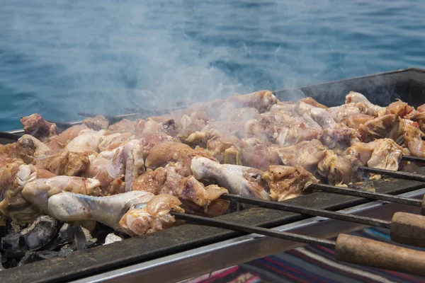 Bir Barbekü tropikal deniz arka plan ile pişirme tavuk — Stok fotoğraf