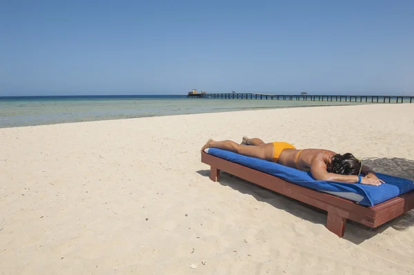 Mulher tomando banho de sol em uma praia tropical — Fotografia de Stock