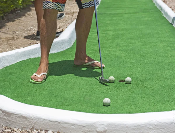 Person spielt Minigolf Putten am Loch — Stockfoto