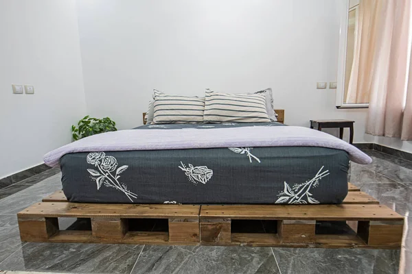 Interior design decor furnishing of luxury show home bedroom showing furniture and double bed on pallets