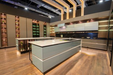 İç dizayn dekorasyonu lüks apartman galerisindeki adalı ve dolaplı büyük modern mutfağı gösteriyor.