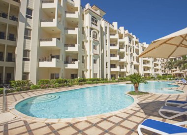 Lüks bir tropikal otel tesisinde güneşli havuz.