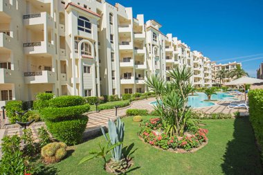 Lüks bir tropikal otel tesisinde bahçeli büyük bir yüzme havuzu.