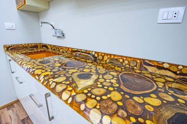 İç epoksi reçine ve ahşap ağaç blokları tasarımı modern mutfağı dolaplarla ve lüks apartman galerisinde lavaboyla gösteriyor.