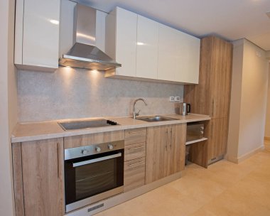 Lüks apartman galerisindeki modern mutfak ve aletleri gösteren iç dizayn dekorasyonu.