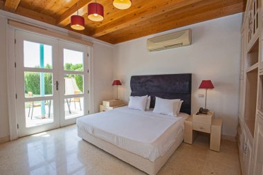 Lüks mobilyaların iç tasarım dekorasyonu ev odası mobilyaları ve teras manzaralı çift kişilik yatakları gösteriyor.