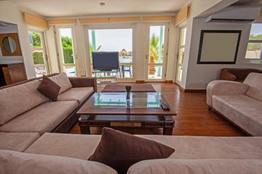 Lüks tropikal tatil köşkündeki oturma odası oturma odası iç tasarım dekorasyonunu açık tasarım döşenmiş olarak gösteren evi gösteriyor.