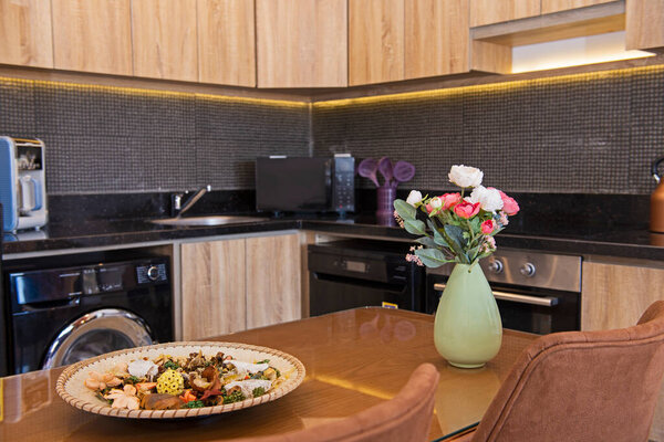 Kitchen area in luxury apartment show home showing open plan interior design decor furnishing with dining table