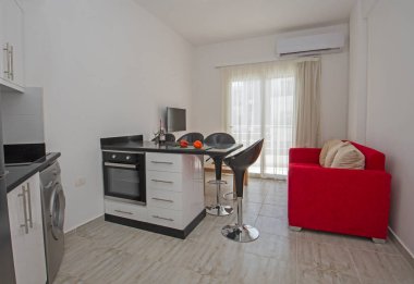 Lüks apartmandaki oturma odasının oturma odası ev dekorasyonunu gösteriyor. Mutfak döşenmiş.
