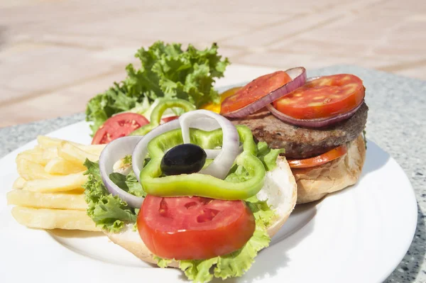Крупный план говяжьего бургера с салатом — стоковое фото