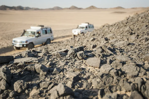 Vehículos que conducen a través del desierto rocoso —  Fotos de Stock