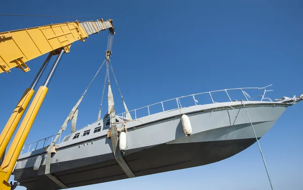 Boat being lifted by heavy crane machinery — Stock Photo, Image