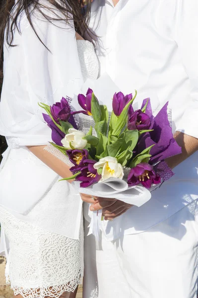 Couple nouvellement marié tenant des fleurs — Photo