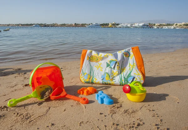 Bolsa de praia e brinquedos na praia — Fotografia de Stock