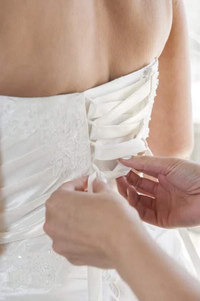 Bride having her dress laced up — Stock Photo, Image