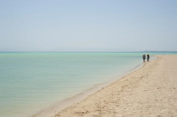 Coppia che cammina su una spiaggia tropicale — Foto Stock