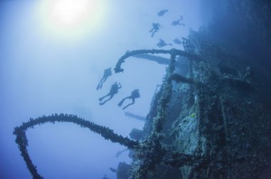 Divers on a deep underwater shipwreck clipart