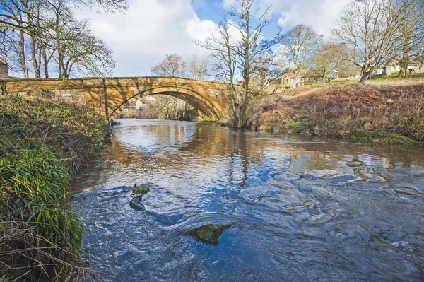 Viejo puente de piedra sobre un arroyo — Foto de Stock