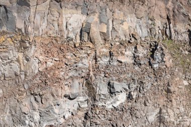 Dik dağın yamacındaki sert, keskin kayalık duvar yamacının yakın plan detayı sanatsal doku duvar kağıdı arkaplan grafik kaynağı