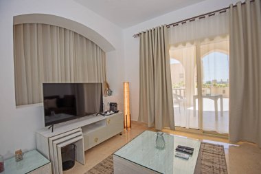 Lüks apartmandaki oturma odası salonu balkon terası döşenmiş iç dizayn dekorasyonunu gösteriyor.