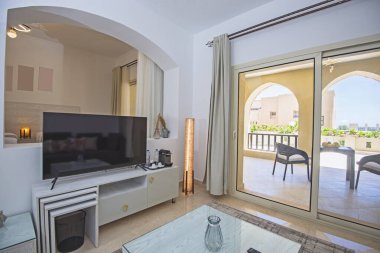 Lüks apartmandaki oturma odası salonu balkon terası döşenmiş iç dizayn dekorasyonunu gösteriyor.