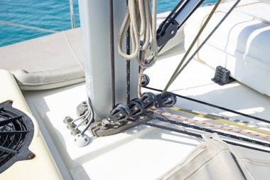 Direk üssünün yakın plan detayları ve lüks bir zevk yelkenlisiyle mavi okyanus arka planında yelken açmak.