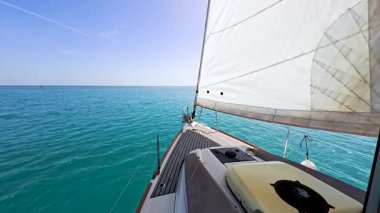 Lüks yelkenli yatın pruvasından manzara. Ana direği ve donanımı mavi okyanus arka planını gösteriyor.